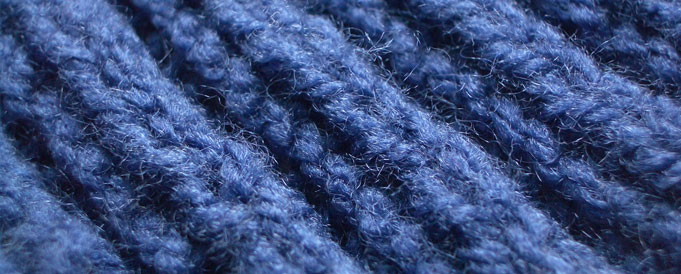 Blau gestrickte Wolle mit heraustreten Fäden.  