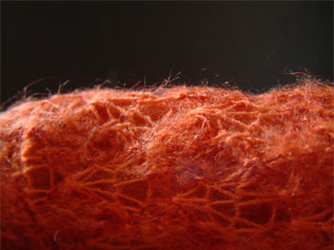 Rote Flusen von gestrickte Wolle